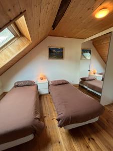勒布罗伊斯The Stable House Bourg d’Oisans -bike/hike/ski的阁楼卧室设有2张床和木制天花板