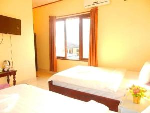 万荣DokPhut Guesthouse的酒店客房设有两张床和窗户。