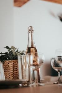 蒂耶尔Le Grand Pirou # Lumineux # Halte Auvergne的一张桌子上放着一瓶葡萄酒,放上两杯