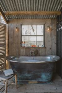 布里德波特Outbuildings Dorset的窗户客房内的大浴缸