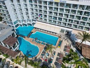 阿依纳帕Vassos Nissi Plage Hotel & Spa的享有酒店游泳池空中景色,设有一座大型建筑