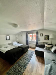 LinnerydSTF Korrö Hotell的一间卧室配有两张床和一张沙发。