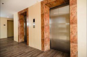 卡加盐德奥罗La Reina Suite Tuscania Towers的电梯,有金属门在房间里