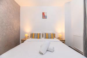 布拉索夫JAD - Comfortable - Apartments - Coresi的卧室配有带两盏灯的白色床