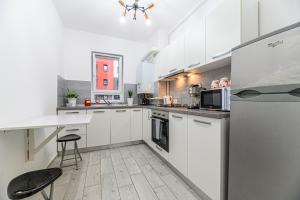 布拉索夫JAD - Comfortable Family Apartments - Coresi的厨房配有白色橱柜和白色台面