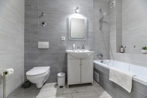 布拉索夫JAD - Comfortable Family Apartments - Coresi的浴室配有卫生间、盥洗盆和浴缸。