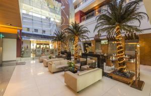 纳威孟买滕伽里根扎酒店的商场里一个带长沙发和棕榈树的大堂