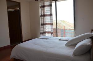 拉利贝拉Zan-Seyoum Hotel - Lalibela的卧室配有白色的床和大窗户