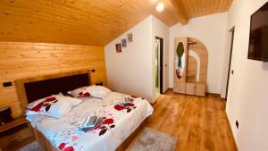 Statjunea BorsaCasa dintre Brazi的木制客房内的一间卧室,配有一张床