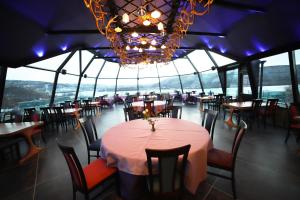 乌茨约基Utsjoki Arctic Resort的一间带桌椅和吊灯的用餐室