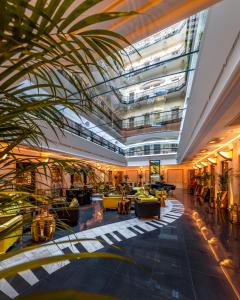 布达佩斯布达佩斯图书馆酒店集团咏叹调酒店的大堂,在大楼内种植棕榈树