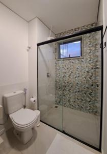 戈亚斯州上帕莱索Casa dos Lírios的一间带卫生间和玻璃淋浴间的浴室