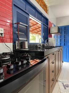 戈亚尼亚Pousada Flor de Alecrim para quem sabe escolher a 10 min da Jeep的厨房拥有蓝色和红色的墙壁,配有炉灶