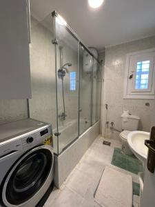阿莱曼Marina 7 4BR Villa lake view的带淋浴的浴室内的洗衣机