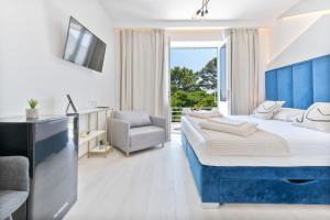 布雷拉Aurora Beachfront Luxury Rooms&Suites的酒店客房带一张大床和一把椅子