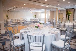 纽波特纽波特港码头酒店的宴会厅配有白色的桌椅和鲜花