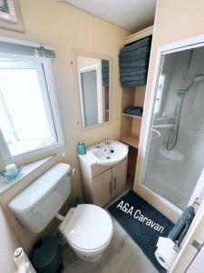 滨海莱斯当A&A Caravan Holidays的浴室配有卫生间、盥洗盆和淋浴。