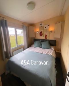 滨海莱斯当A&A Caravan Holidays的一间卧室设有一张床和一个窗口