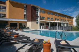 孔格林宜必思高尔夫圣特洛佩兹酒店的酒店游泳池设有椅子,酒店大楼