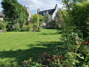 阿伯劳尔Aberlour Cottages - Bolthole & Retreat的花园设有大草坪和房屋