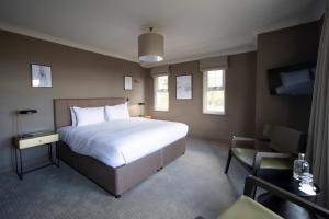 大莫尔文力推林中小屋酒店的一间卧室配有一张大床和一把椅子