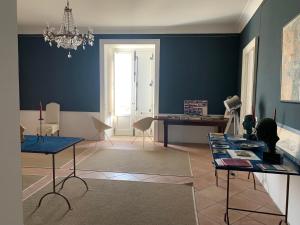 阿曼泰阿Palazzo Carratelli的客厅设有蓝色的墙壁、桌子和吊灯。