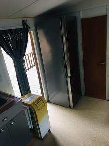 塞里尼昂Mobil-home sur terrain privé的空房间,设有冰箱和窗户