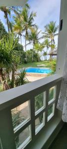 阿拉亚尔达茹达Vista para o mar Arraial d'Ajuda的设有一个游泳池的度假村阳台,享有风景