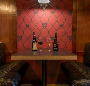怀特霍斯Sternwheeler Hotel and Conference Centre的一张桌子,上面放有两瓶和一杯葡萄酒