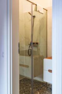 锡比乌Sia Boutique Aparthotel的浴室里设有玻璃门淋浴