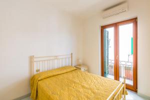 伊斯基亚Friendly&Family Apartment at Ischia的一间卧室配有一张带黄色床罩的床和窗户