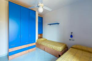 伊斯基亚Friendly&Family Apartment at Ischia的一间卧室设有两张床和蓝色的橱柜