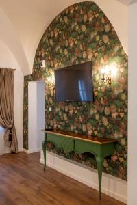 锡比乌Sia Boutique Aparthotel的客厅配有绿色钢琴,靠着花卉墙壁