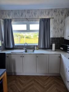 CurrHill view Cottage的厨房设有水槽和窗户。