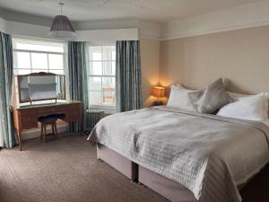 博格诺里吉斯Navigator Hotel的一间卧室配有一张床、一张书桌和一面镜子