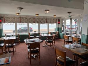 博格诺里吉斯Navigator Hotel的一间带桌椅的海景餐厅