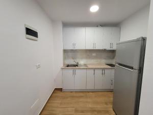 卡萨米尔Villa JIOTA的厨房配有白色橱柜和不锈钢冰箱