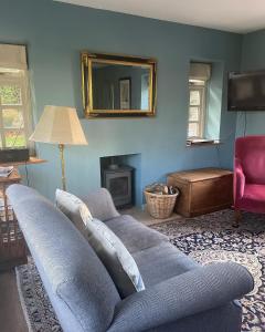 莱德林赫The Old Coach House的带沙发和镜子的客厅