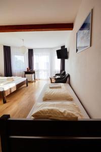 尼彻兹VIPABO SolneSPA - Sauna, Grota Solna, Łaźnia parowa的一间卧室设有两张床,墙上配有电视。