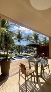 卡姆布库Carmel Cumbuco Resort的一个带桌椅的庭院和一个游泳池