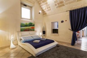 莱切Suite Paisiello的卧室配有一张床,墙上挂有绘画作品