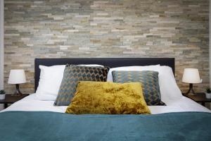布莱克浦Seaside Suite 1 - Beautiful Long Stay Studio on Lord Street的一张带两个枕头和砖墙的床