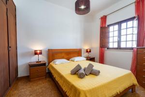 科武港Apartamentos Capitão by Umbral的一间卧室配有黄色的床和2条毛巾