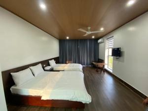 Cẩm XuyênHOMESTAY THIÊN CÂM的一间卧室配有两张床和一台平面电视