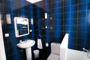 大加那利岛拉斯帕尔马斯Nomad Villa Santa Fe的蓝色瓷砖浴室设有水槽和卫生间