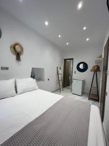 斯基亚索斯镇reAdy studio的卧室配有白色的床和墙上的一顶帽子