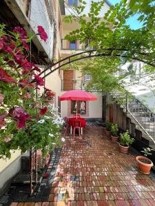 埃里温Your Home (YH)的一个带红色桌子和红色遮阳伞的庭院