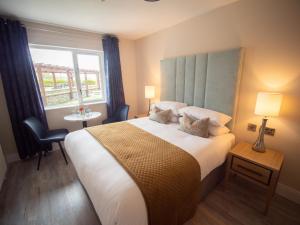 恩尼斯克朗Ocean Sands Hotel的一间卧室设有一张大床和一个窗户。