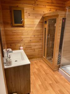 ArthonRomantique chalet avec sauna et jacuzzi extérieur的木制客房内的带水槽的浴室