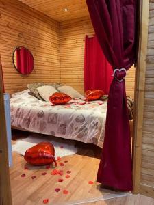 ArthonRomantique chalet avec sauna et jacuzzi extérieur的卧室配有一张红色的床,位于地板上